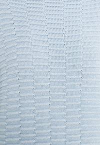 Ljusblå stickad tröja med ett strukturerat mönster, med växelvis horisontella och vertikala linjer, mjukt material.