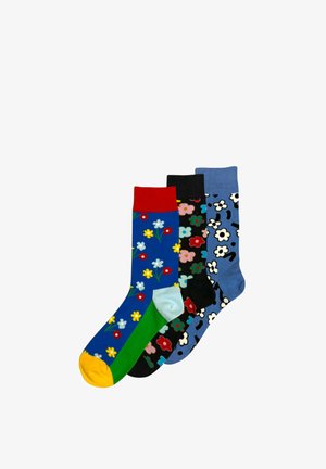 Tre calzini colorati con motivi floreali: blu con risvolto rosso e punta gialla, nero con fiori multicolore e blu con fiori bianchi.