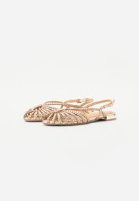 Roze gouden platte sandalen met een geweven ontwerp, met een verstelbare enkelband en een kleine metalen accent op de hiel.
