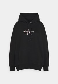 Czarna bluza z kapturem wykonana z bawełny; posiada przednią kieszeń oraz różowe logo „CALVIN KLEIN JEANS”. Luźny krój i ściągacze przy rękawach.