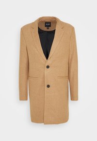 Cappotto in lana beige con rever, due tasche frontali, chiusura con un solo bottone e fodera interna nera. Maniche lunghe, vestibilità aderente.