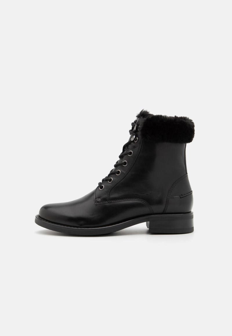 Bota de ankle de couro preto com gola de pelúcia sintética, bico arredondado, frente com atacadores e salto bloco baixo. Acabamento suave com detalhes metálicos.