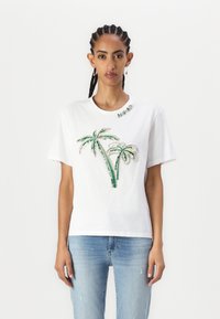 T-shirt bianca in cotone con design a palme in paillettes verdi e argento sulla parte anteriore, scollatura tonda e maniche corte.