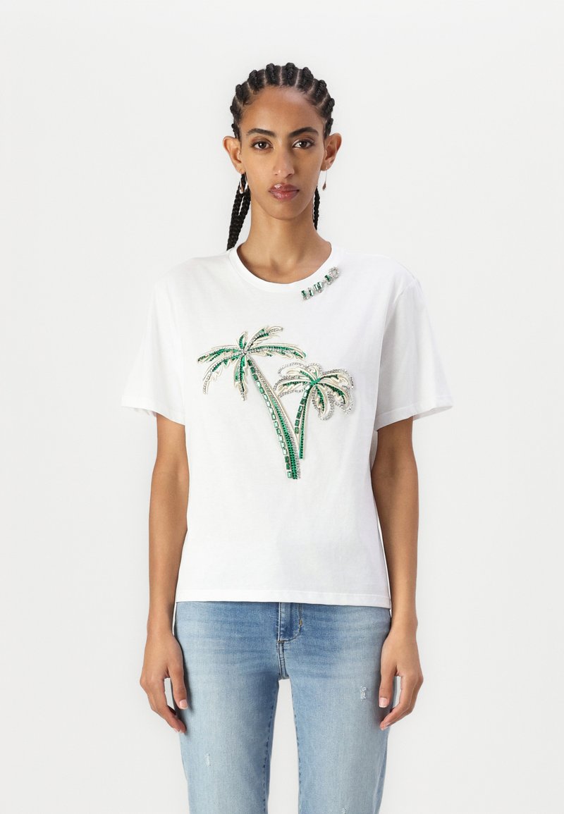 T-shirt bianca in cotone con design a palme in paillettes verdi e argento sulla parte anteriore, scollatura tonda e maniche corte.