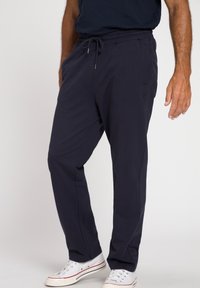 Pantaloni jogger blu navy realizzati in misto cotone. Vita elastica con cordoncino, tasche laterali e discreto dettaglio del logo. Texture liscia.