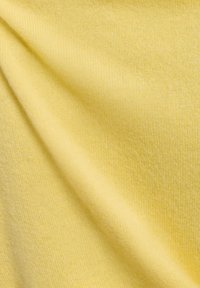 Helles gelbes Gewebe mit einer glatten Textur, das einen subtilen Glanz zeigt. Die Webart ist gleichmäßig und hat ein weiches, dehnbares Gefühl.