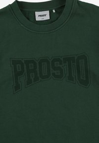 Ciemnozielony sweter z dużym, lekko wypukłym czarnym logo "PROSTO" na przodzie. Wykonany z miękkiego materiału bawełnianego z prążkowanym kołnierzem.