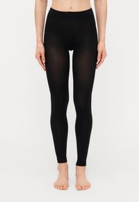 Sorte tights laget av et elastisk materiale, med høy midje og en glatt, sømløs design som sitter tett til beina.