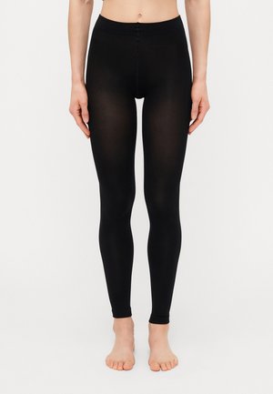 Sorte tights laget av et elastisk materiale, med høy midje og en glatt, sømløs design som sitter tett til beina.