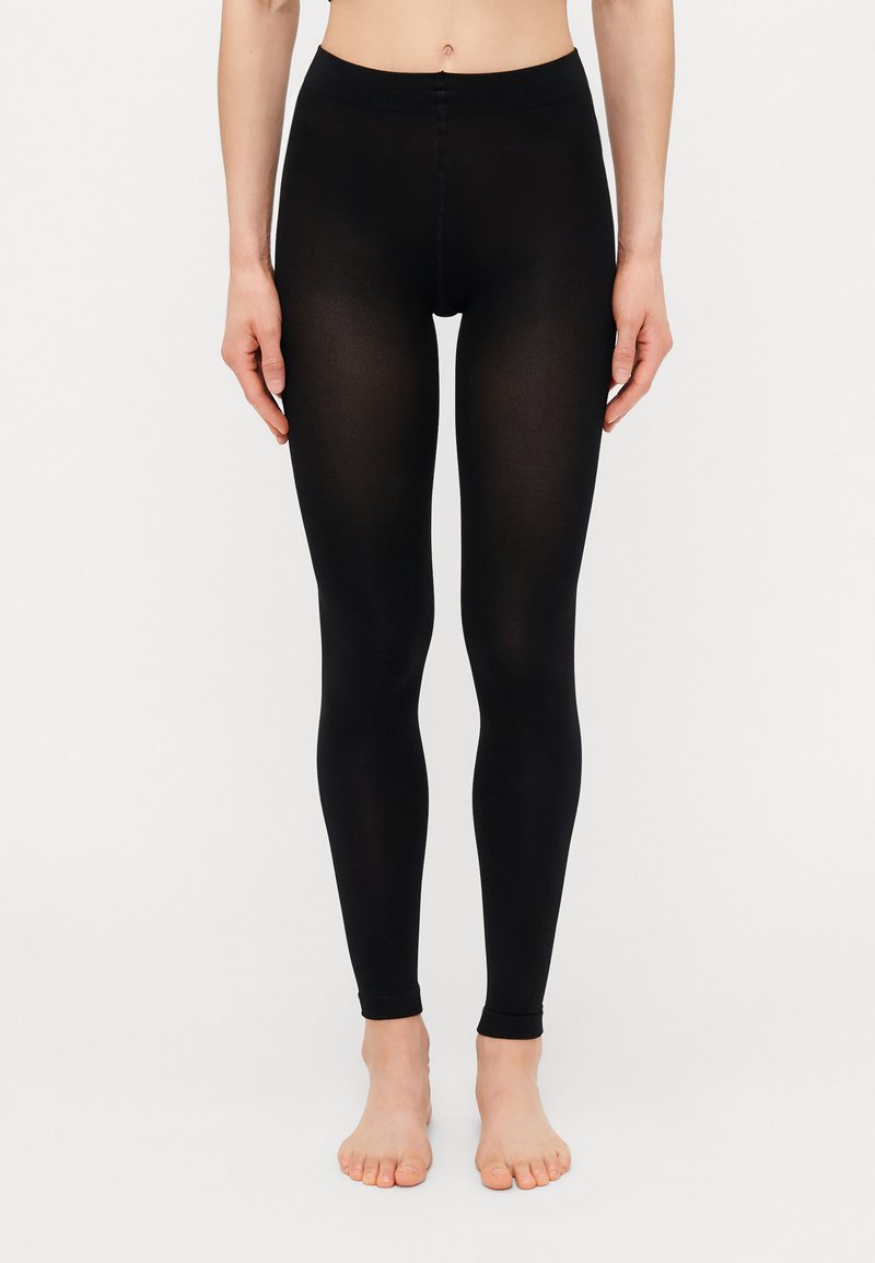 Sorte tights laget av et elastisk materiale, med høy midje og en glatt, sømløs design som sitter tett til beina.