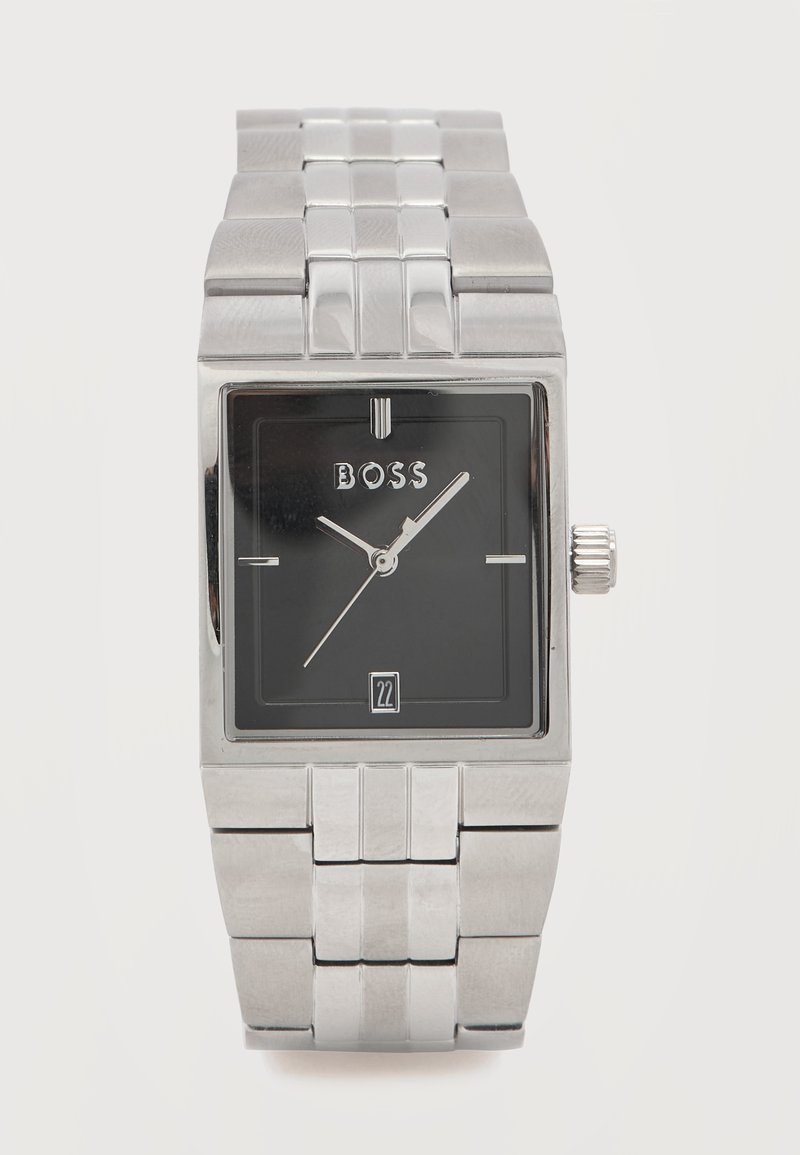 Ορθογώνιο ασημένιο ρολόι χειρός με μαύρο καντράν,  ασημένιους δείκτες ώρας και λεπτών, ένδειξη ημερομηνίας στις έξι η ώρα και λογότυπο "BOSS" κάτω από τις δώδεκα η ώρα.