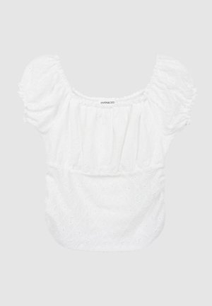 Hvid bluse med pufærmer, blomsterformet hulmønster, elastisk halsudskæring og talje, blød tekstur og afslappet pasform. Mærketikette synlig.