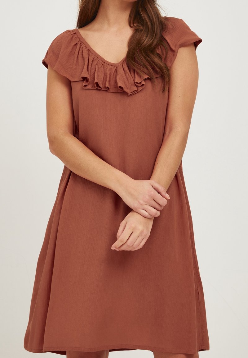 Roestkleurige jurk met een V-hals en rimpelige kapmouwen. Gemaakt van lichtgewicht stof, met een relaxte pasvorm en subtiele textuur.