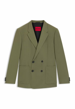 Blazer de doble botonadura color verde oliva hecho de tela texturizada, con dos bolsillos frontales y detalles de botones negros. El interior tiene una etiqueta roja.