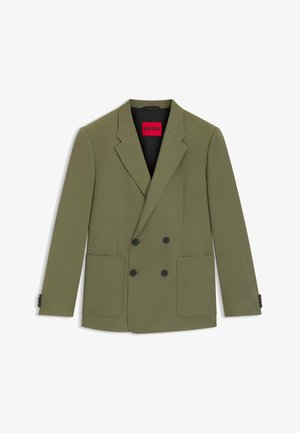 Blazer croisé vert olive en tissu texturé, doté de deux poches frontales et d'accents de boutons noirs. L'intérieur comporte une étiquette rouge.