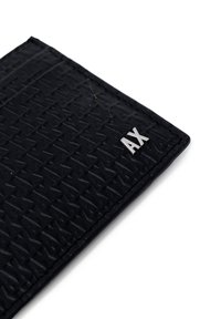 Black wallet made of textured material with a raised pattern. Features a silver "AX" logo attached. Edges are stitched.