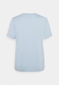 Camiseta de manga corta azul claro, hecha de algodón suave. Cuello redondo, corte recto y una textura lisa sin logos ni patrones visibles.