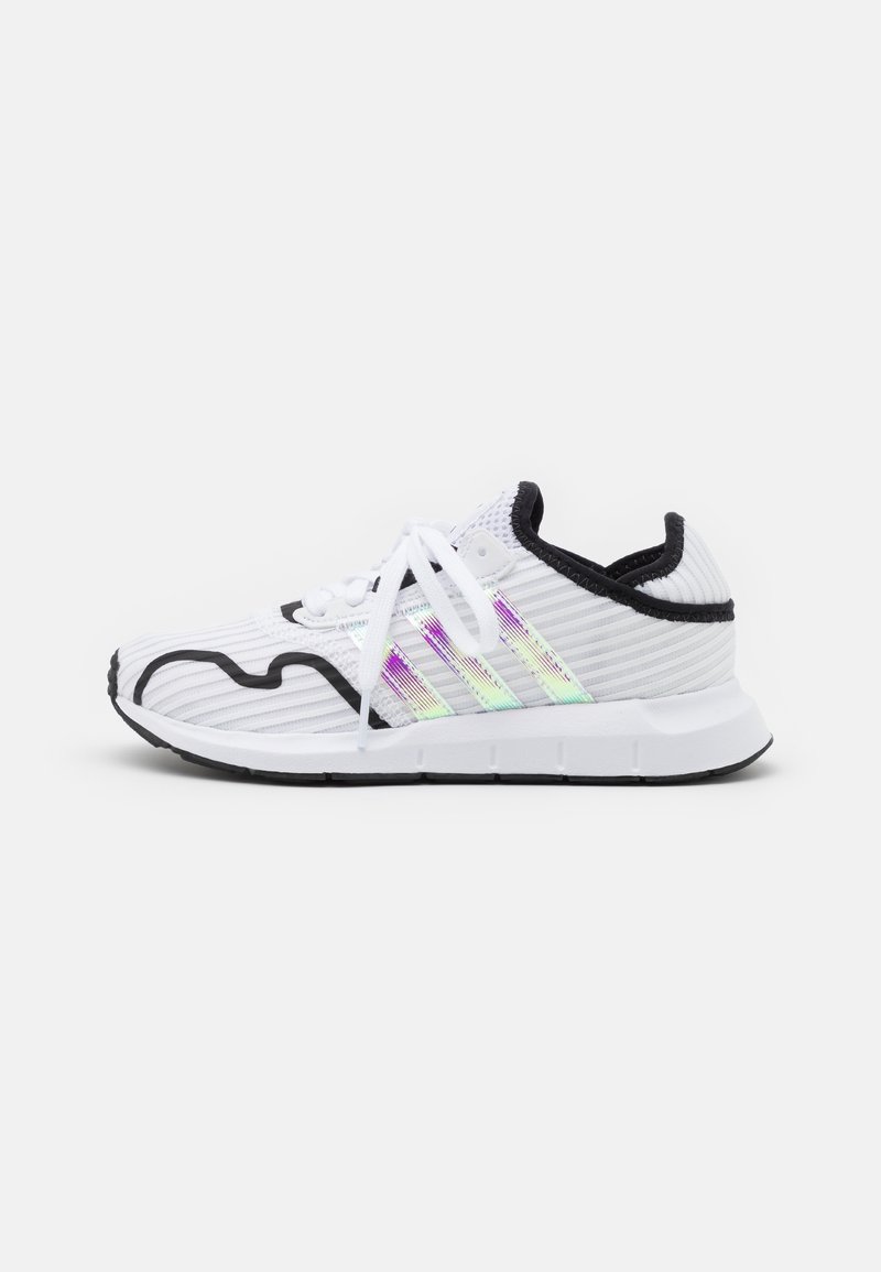 Chaussure de sport blanche avec bordure noire, trois bandes irisées sur le côté, lacets blancs et semelle noire et blanche, vue du côté intérieur.
