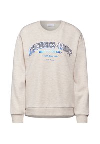 Felpa di un beige chiaro realizzata in materiale morbido. Presenta un testo e accenti blu bold, con frasi stampate in colori a contrasto.
