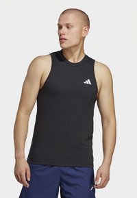 Melns sporta krekls bez piedurknēm ar apaļu apkakli, kreisajā krūtīs mazs balts adidas logotips.