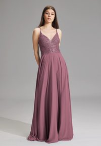 Robe longue et fluide en tissu mauve avec un corsage ajusté en sequins. Dispose de fines bretelles et d'un décolleté en V profond. Texture douce, design élégant.