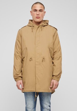 Chaqueta color marrón claro, hasta la cadera, con capucha ajustable, bolsillos laterales y puños elásticos. Tejido suave con una textura sutil y diseño de corte holgado.