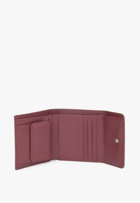 Burgundzka skórzana portmonetka o gładkiej fakturze, z wieloma kieszeniami na karty, zapięciem na zatrzask oraz małą wewnętrzną kieszonką.