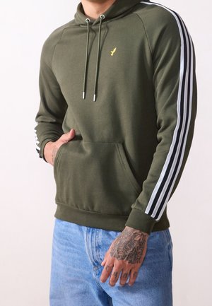 Sudadera verde oliva con acentos de rayas blancas en las mangas, bolsillo tipo canguro en la parte delantera, capucha con cordón y puños de canalé. Material de algodón suave.