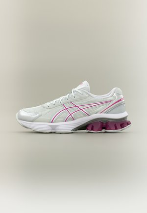 Baskets de sport blanches et roses avec tige en mesh, semelle rembourrée et maintien distinctif du talon violet segmenté.