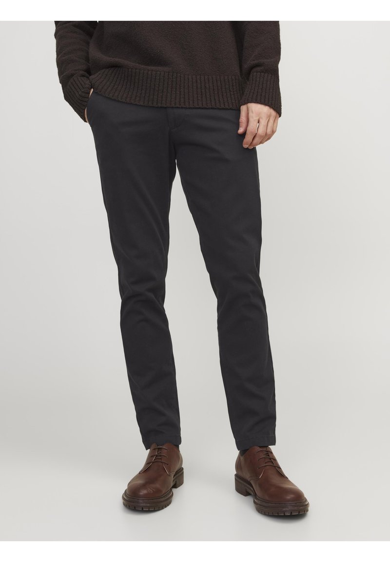 Mörk marinblå chinos i mjukt tyg, med slim fit-design, sidofickor och en ren finish, matchade med bruna snörskor.