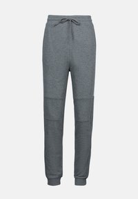 Grå joggebukser med snøring i livet, myk tekstur og kontrasterende knepaneler. Smale ben med ribbestrikkede mansjetter.