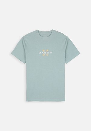 T-shirt bleu clair à manches courtes. Présente un logo Oxbow blanc et jaune sur le devant. Fabriqué en tissu doux avec un col rond.