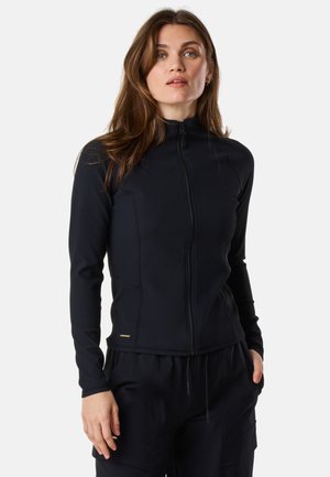Black zip-up jacket with ribbed texture, high collar, and long sleeves. Features a gold accent near the hem, paired with dark trousers.