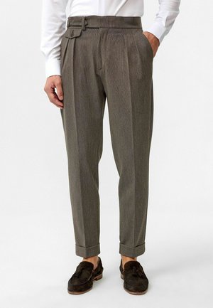 Grijze geplooide broek met een slim fit, met een platte voorkant, zijzakken en een gordel met lussen. Gemaakt in combinatie met donkere schoenen.