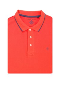 Czerwona koszulka polo z teksturowanej tkaniny, z kołnierzykiem w granatowe akcenty, trzema guzikami i niebieskim logo blisko dołu.