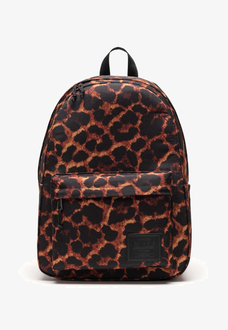 Mochila de estampado de leopardo negro y marrón con un asa en la parte superior, bolsillo frontal con cremallera y una tela texturizada. Presenta un parche de logo en el frente.