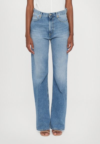 Jeans en denim bleu clair à taille haute et jambes larges. Présente un design classique à cinq poches et un zip. Texture lisse avec un léger dégradé.