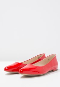 Czerwone baleriny z lakierowanej skóry, z ozdobnym, szpiczastym noskiem, płaską podeszwą i gładkim, błyszczącym wykończeniem. Rozmiar 37 oznaczony po wewnętrznej stronie.