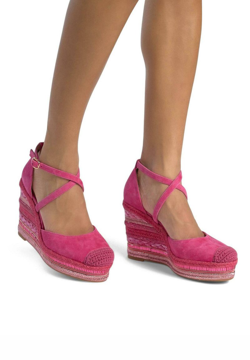 Sandalias de cuña de ante rosa fucsia con diseño de tiras cruzadas, punta texturizada y tacón tejido de varios patrones.
