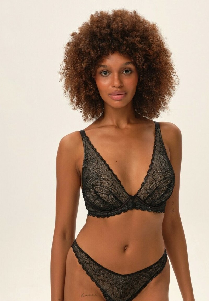 Czarny koronkowy stanik i pasujące majtki w stylu bikini, ozdobione kwiatowymi wzorami, ze falbaniastymi krawędziami i cienkimi ramiączkami. Gładka, półprzezroczysta tekstura.