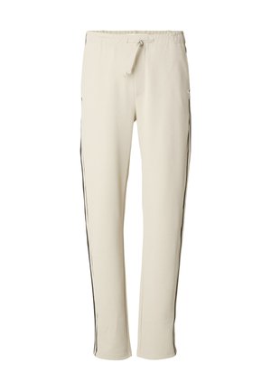 Pantalon de survêtement couleur crème en tissu doux, doté d'une taille à cordon et de bandes latérales noires courant le long des jambes.