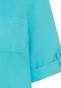 Camicia turchese con bottoni, maniche arrotolate, realizzata in tessuto leggero. Presenta una tasca sul petto e una finitura liscia e strutturata.