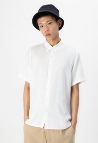 Witte short-sleeve shirt met een button-down kraag, gemaakt van lichtgewicht stof, met een relaxte pasvorm en subtiele textuur.
