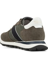 Zapatilla de ante marrón y oliva con un diseño en blanco y marino, forma redondeada, suela acolchada y detalles cosidos. Presenta un logo en el talón.