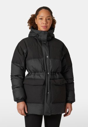 Zwarte gewatteerde jas met een trekkoord capuchon, knoopsluiting, twee grote voorzakken en elastische manchetten. Heeft een getailleerde taille voor een goede pasvorm.