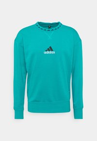 Sweat-shirt turquoise en mélange de coton avec manches longues, encolure ronde et logo Adidas noir sur la poitrine et le col.