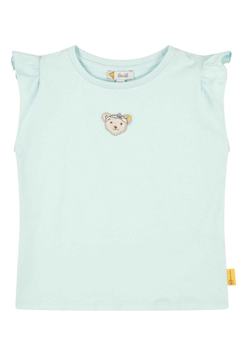 Camiseta de algodón azul claro con mangas cortas con volantes y un bordado de cara de oso en el frente. Presenta una pequeña etiqueta amarilla en el costado.