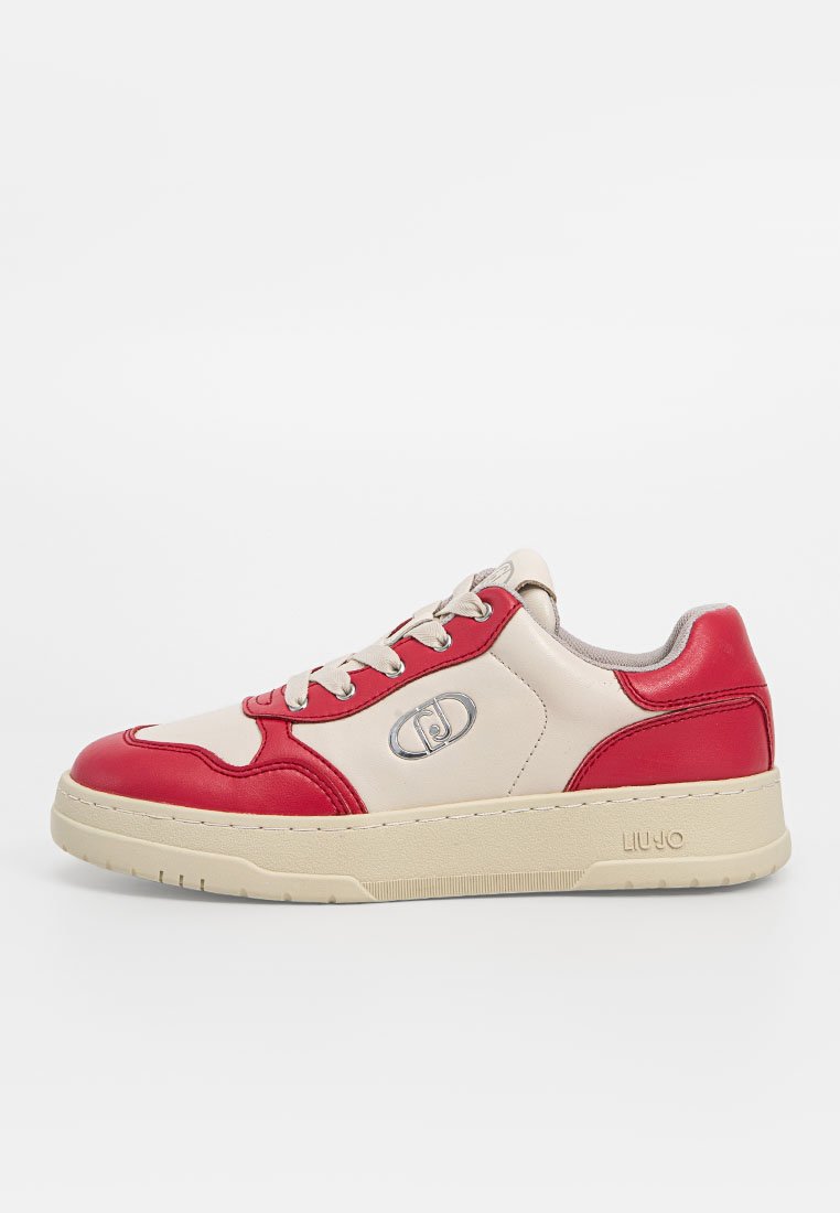 Zapatillas con parte superior de cuero beige y acentos rojos, punta redondeada, diseño con cordones y suela de goma texturizada beige. Detalle del logo en plata.