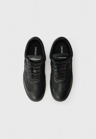 Black leather sneakers with round toes, lace-up design, cushioned insoles, and brand logo on the tongue and side. Smooth texture.