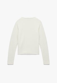 Crème lange mouw cropped top van zachte katoen, met een eenvoudige halslijn en getailleerde mouwen. Geen extra patronen of details.